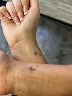 a woman's arm with a small star tattoo on it and her left wrist