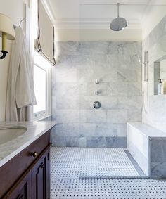 a bathroom with a sink, toilet and shower in it's own area that has white tile on the floor