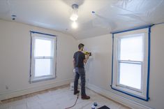 a man is painting the walls in an empty room