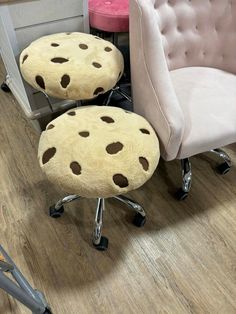 two stools with holes on them sitting in front of a pink chair and ottoman