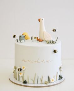 a white cake decorated with animals and bees