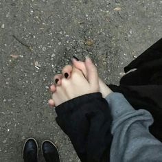 a person standing on the ground holding their hands together