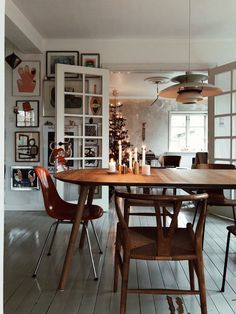 a dining room table with chairs and candles on it