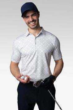 a man holding a golf club and ball in one hand while smiling at the camera