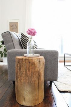 a living room with a couch, chair and flower vase on the table in front of it