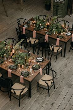 an overhead view of a table set with place settings and greenery on the tables