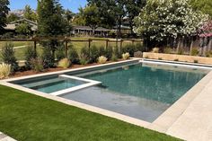 an empty swimming pool surrounded by lush green grass