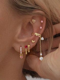 a close up of a person wearing ear piercings with hearts and stars on them