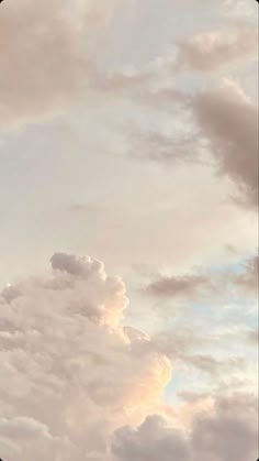 an airplane is flying through the cloudy sky