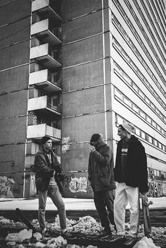 three men standing in front of a tall building