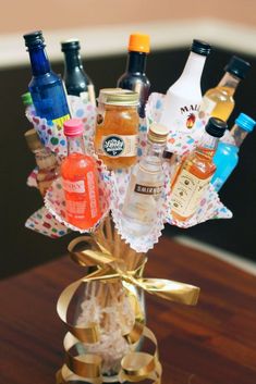 a vase filled with lots of different types of condiments on top of a wooden table