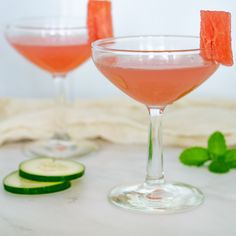 two wine glasses filled with watermelon and cucumber garnishments