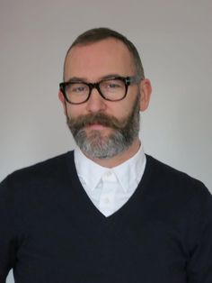 a man with glasses and a beard wearing a sweater