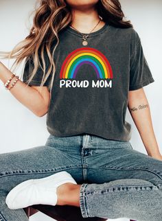 a woman sitting on top of a stool wearing a shirt that says proud mom