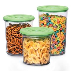 three glass containers filled with cereal and pretzels next to each other on a white background