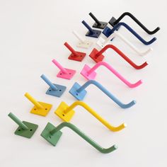 several different colored plastic handles on a white surface