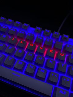 a close up view of a keyboard with red and blue light coming from the keys