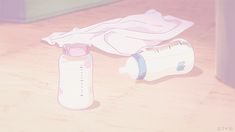 a baby bottle and breast milk sitting on a wooden floor next to an empty bottle