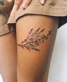 a close up of a person's thigh with flowers on it and the bottom half of her leg