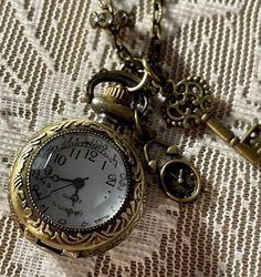 Pocket Watch Necklace. Pocket Watch  Measures 1". Antique Bronze Tone. Necklace Has A Lobster Claw clasp. Chain Is  28" Long. Necklace Includes Key,Rhinestones and More.  Durable Stainless Steel Material With a Simple Dial. It Is Easy To See Arabic Numbers, Lobster Claw Clasp.  Battery operated; Press top knob to open the lid, pull up the top knob to adjust the time. Dark Academia Accessories Necklaces, Gold Metal Pocket Watch Nickel Free, Gold Metal Pocket Watch With Chain, Valentina Core, Dark Academia Accessories, Clock Necklace, Fairy Grunge Aesthetic, Arabic Numbers, Unique Watches