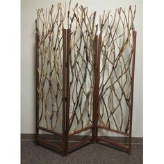 a room divider made out of branches in front of a wall