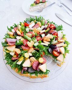 a salad on a platter with cheese, lettuce and other toppings