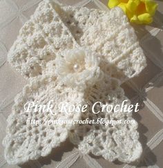 a crocheted flower sits on top of a table next to a yellow flower