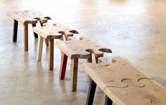 four wooden benches sitting on top of a cement floor next to each other with holes in them