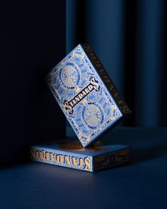 two blue playing cards sitting on top of each other in front of a black background