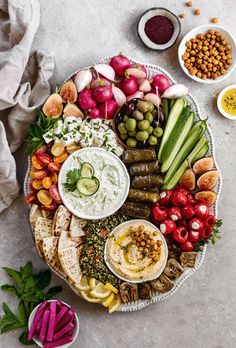 a platter filled with assorted vegetables and dips on top of a table