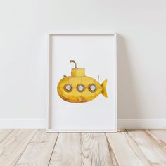 a yellow submarine with eyes and nose is shown in a white frame on the floor