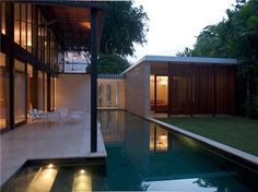 an outdoor swimming pool next to a house with glass doors and windows on the side