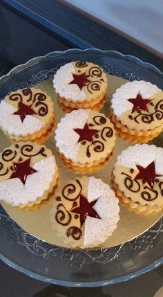 six decorated cookies sitting on top of a glass plate