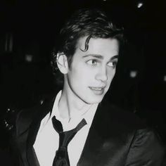 black and white photograph of a young man wearing a suit with a tie on his lapel