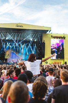 a man standing on top of a stage in front of a large group of people