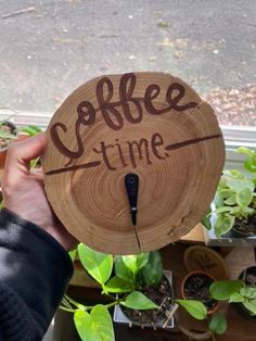 someone holding up a clock made out of a piece of wood with the words coffee time written on it