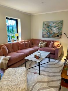 a living room filled with furniture and a large painting hanging on the wall above it