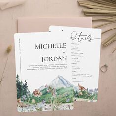 wedding stationery with mountains and flowers on it