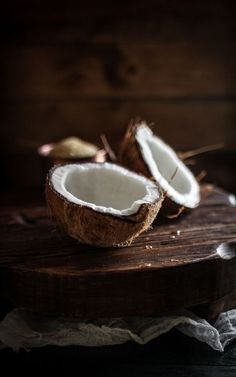 two pieces of coconut sitting on top of a wooden cutting board