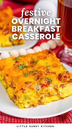 a white plate topped with breakfast casserole on top of a red table cloth