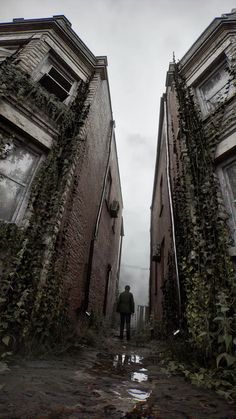 a man standing in between two buildings with ivy growing on them