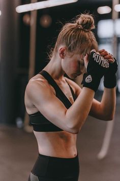 a woman in a black sports bra top and boxing gloves