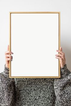 a person holding up a white board in front of their face with one hand and the other