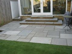 a patio with steps leading to the back door