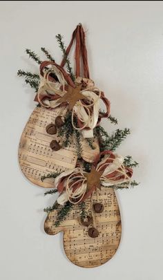 a pair of shoes hanging on a wall with music notes and evergreen branches attached to it