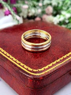 two wedding rings sitting on top of a wooden box