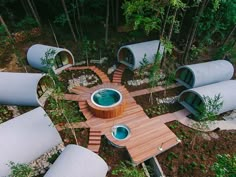 an aerial view of a hot tub in the middle of a forest with wooden steps leading up to it