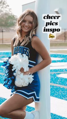 a cheerleader posing for the camera with her pom poms in front of a pole