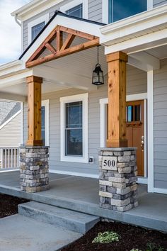 the front porch is made out of stone and has an attached pergolated roof