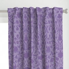 a purple curtain hanging on the side of a window